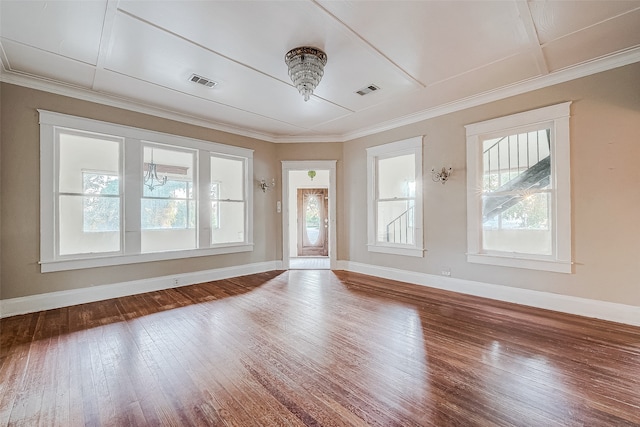 spare room with a wealth of natural light, hardwood / wood-style floors, and crown molding