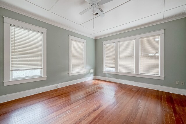 spare room featuring wood-type flooring, a wealth of natural light, crown molding, and ceiling fan