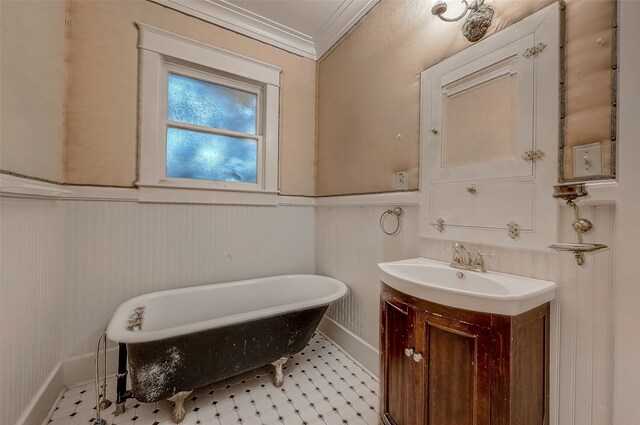 bathroom with a bathtub, ornamental molding, and vanity