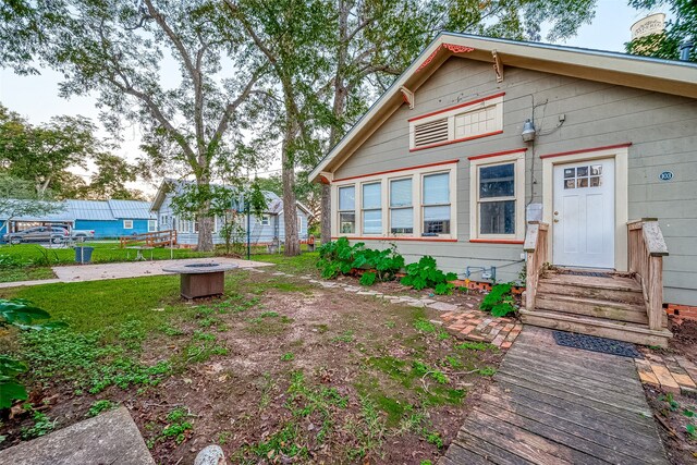 exterior space featuring an outdoor fire pit and a lawn