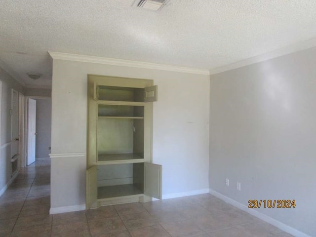 empty room with a textured ceiling and ornamental molding