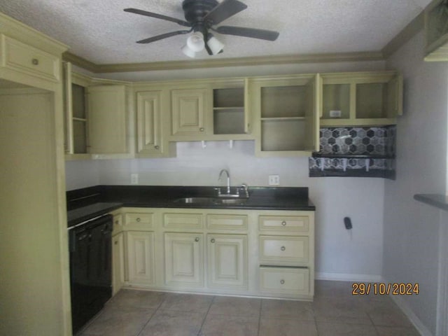 kitchen with dishwasher, sink, light tile patterned floors, and a textured ceiling