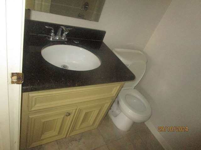 bathroom featuring toilet, vanity, and tile patterned flooring