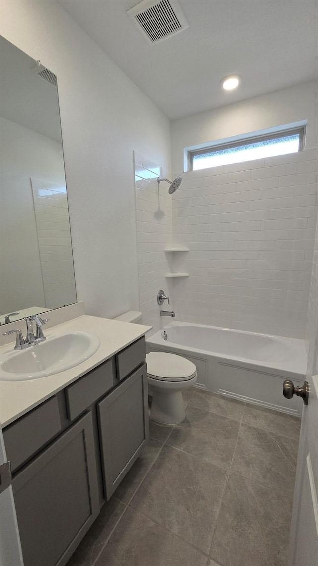 full bathroom with tile patterned flooring, tiled shower / bath combo, toilet, and vanity