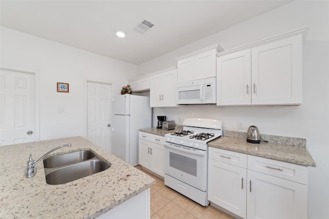 kitchen with white appliances, sink, and white cabinets