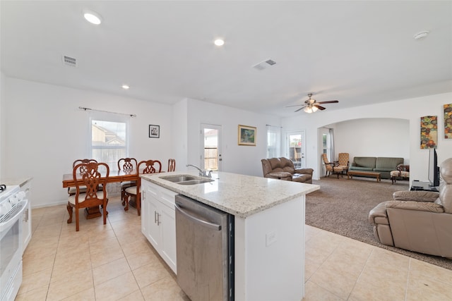 kitchen with white range oven, a center island with sink, white cabinetry, stainless steel dishwasher, and ceiling fan