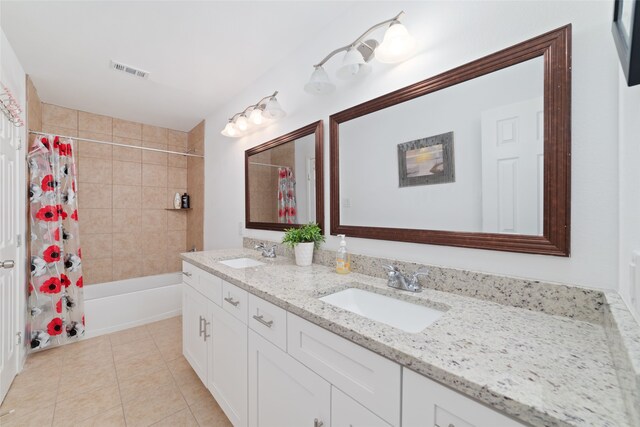 bathroom featuring vanity, shower / bath combo with shower curtain, and tile patterned floors