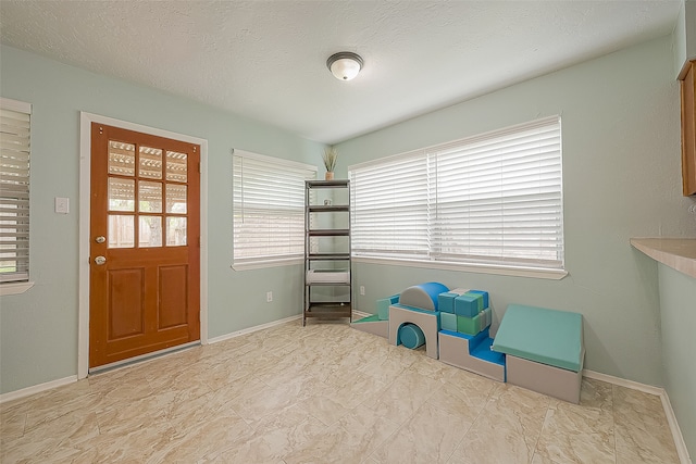 unfurnished room featuring a wealth of natural light and a textured ceiling