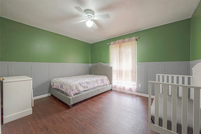 bedroom with ceiling fan, dark hardwood / wood-style floors, and a textured ceiling