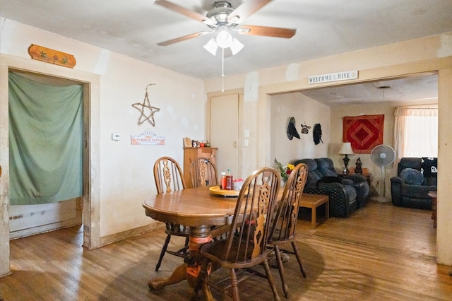 dining area with wood-type flooring and ceiling fan