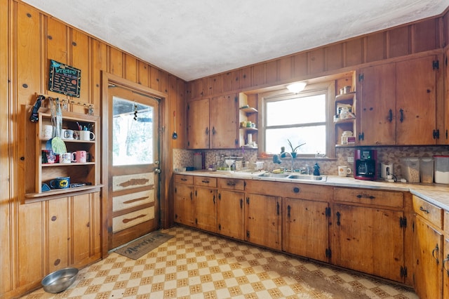 kitchen featuring wood walls, sink, and decorative backsplash