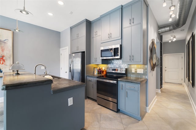 kitchen with stainless steel appliances, sink, light tile patterned floors, backsplash, and pendant lighting