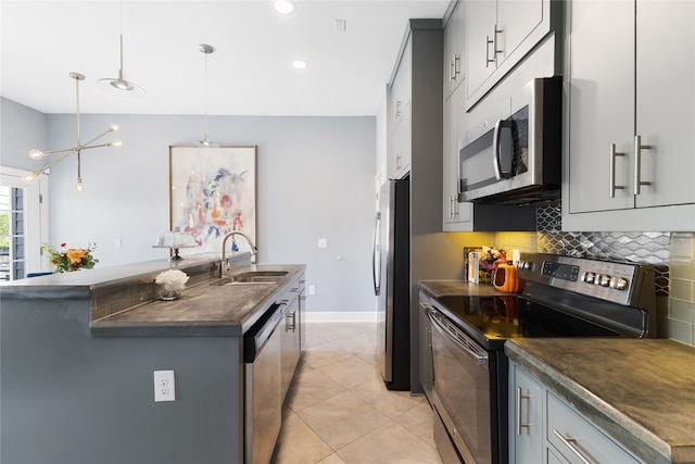 kitchen with sink, appliances with stainless steel finishes, light tile patterned floors, hanging light fixtures, and gray cabinetry