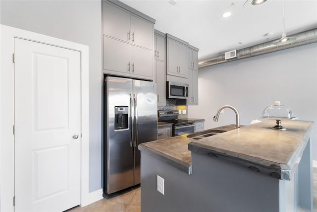 1011 Studemont St Unit 101, Houston, TX 77007 - kitchen with stainless steel appliances, gray cabinets, a sink, dark countertops, and backsplash
