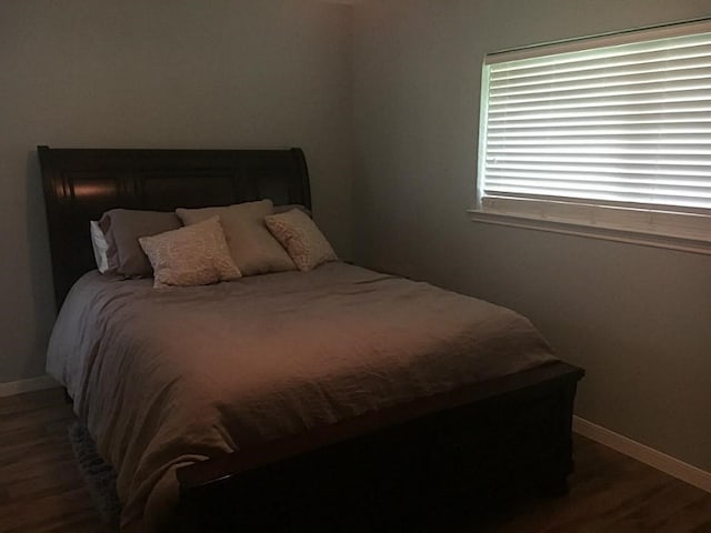 bedroom with dark wood-type flooring