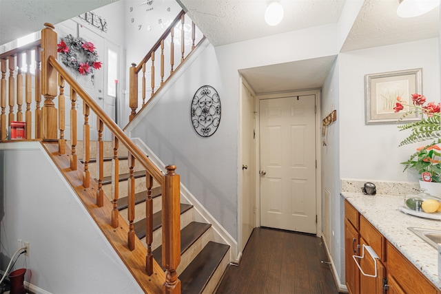 stairs with hardwood / wood-style floors and a textured ceiling