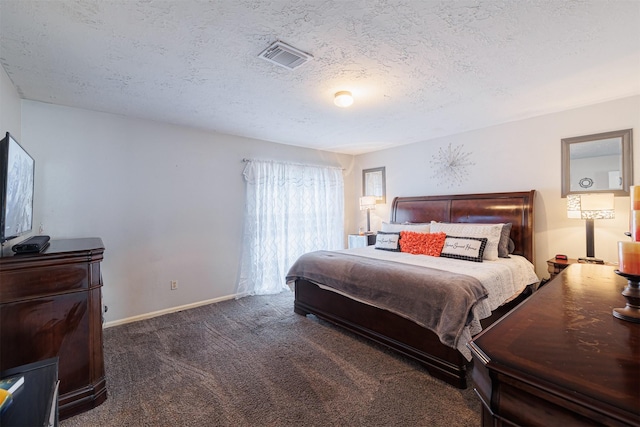 bedroom with dark carpet and a textured ceiling