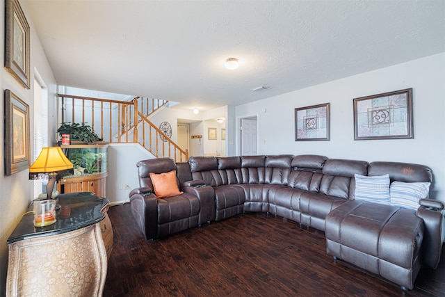 living room with dark hardwood / wood-style flooring and a textured ceiling