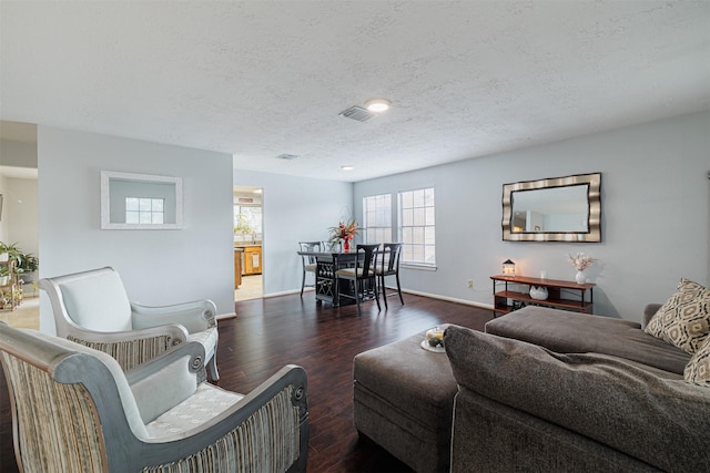 living room featuring a textured ceiling and dark wood-type flooring