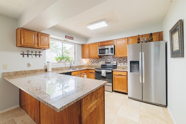 kitchen with kitchen peninsula, light stone counters, stainless steel appliances, sink, and light tile patterned flooring