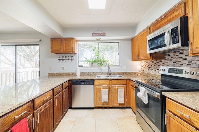 kitchen with sink, light tile patterned flooring, stainless steel appliances, and plenty of natural light