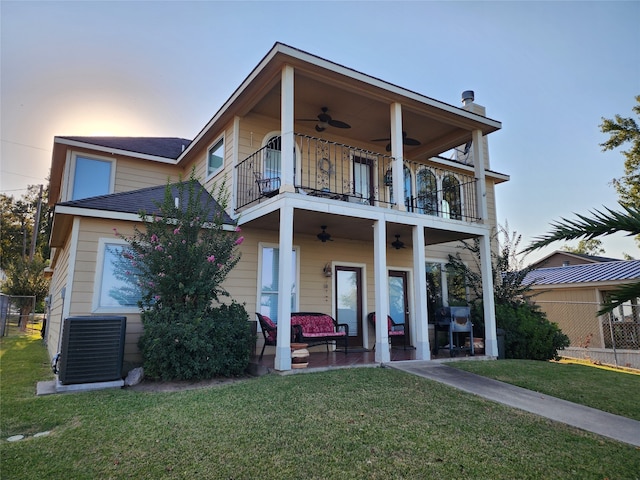 view of front of home featuring ceiling fan, a balcony, a lawn, cooling unit, and a patio area