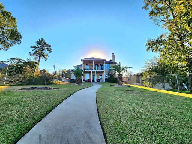 view of front facade featuring a balcony and a front yard