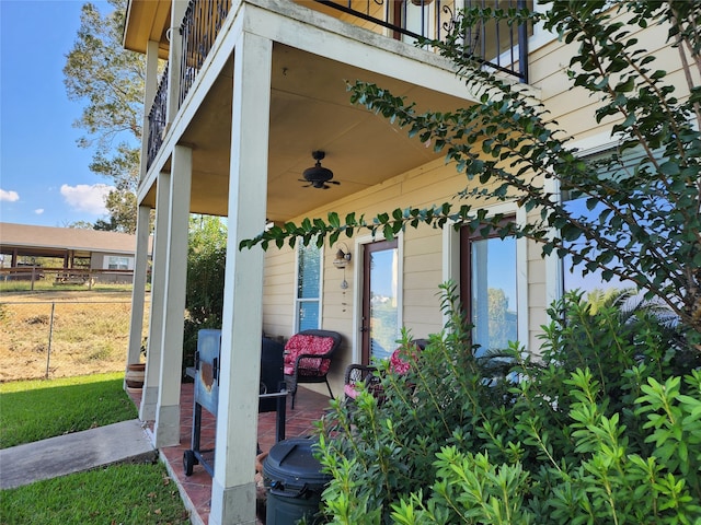 exterior space with ceiling fan and a balcony