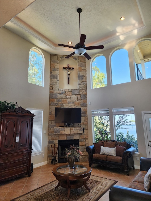 living room featuring a wealth of natural light, a textured ceiling, a tray ceiling, and light tile patterned floors