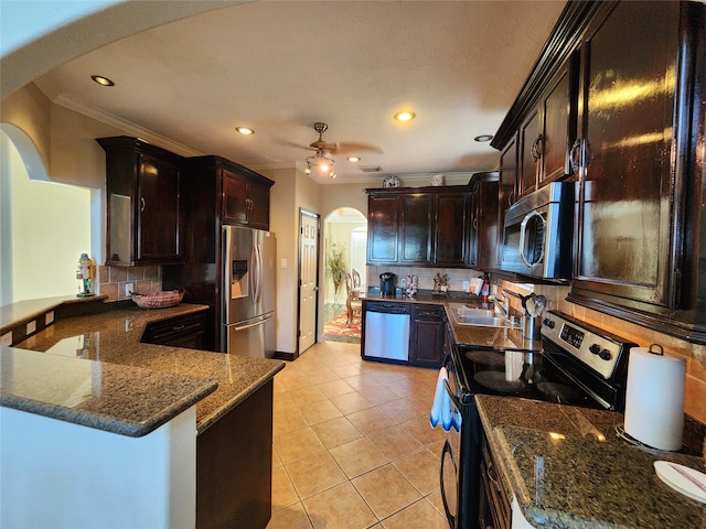 kitchen featuring ornamental molding, decorative backsplash, appliances with stainless steel finishes, and dark brown cabinets