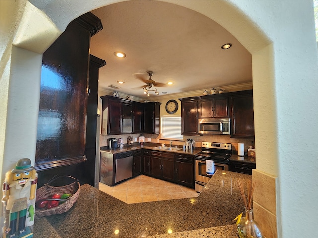 kitchen with sink, dark brown cabinetry, ornamental molding, and stainless steel appliances