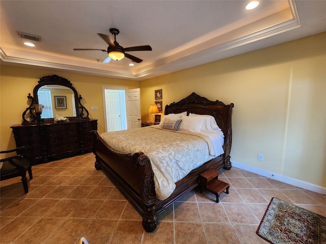 tiled bedroom with ceiling fan and a raised ceiling