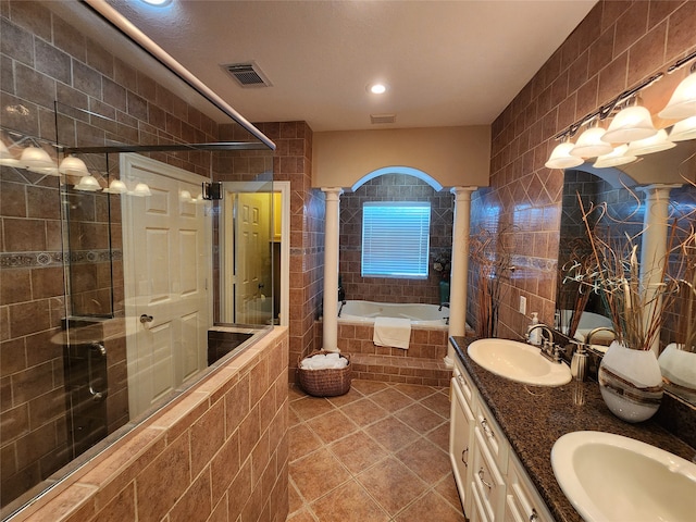 bathroom with tile walls, tile patterned floors, vanity, independent shower and bath, and decorative columns