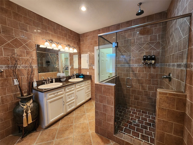 bathroom with tile walls, vanity, tile patterned floors, and a shower with shower door