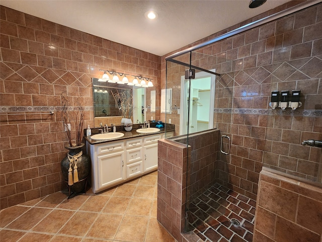 bathroom featuring tile walls, vanity, tile patterned floors, and a shower with door