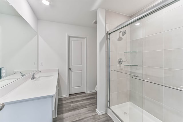 bathroom featuring walk in shower, hardwood / wood-style floors, vanity, and toilet