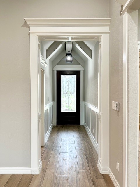 entryway featuring light hardwood / wood-style flooring and lofted ceiling with beams