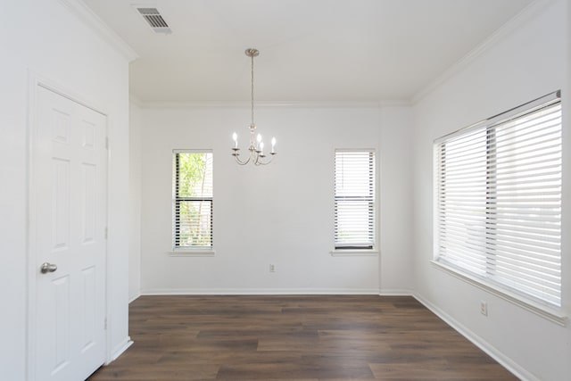 empty room with dark hardwood / wood-style flooring, a notable chandelier, and ornamental molding