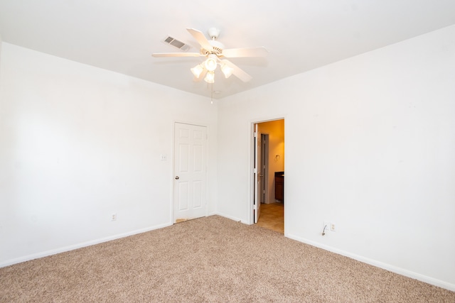 carpeted spare room with ceiling fan