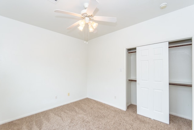 unfurnished bedroom with ceiling fan, light carpet, and a closet