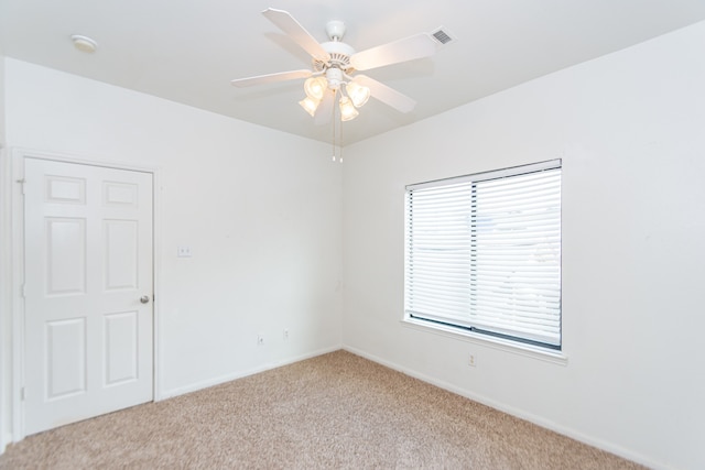 spare room with light colored carpet and ceiling fan