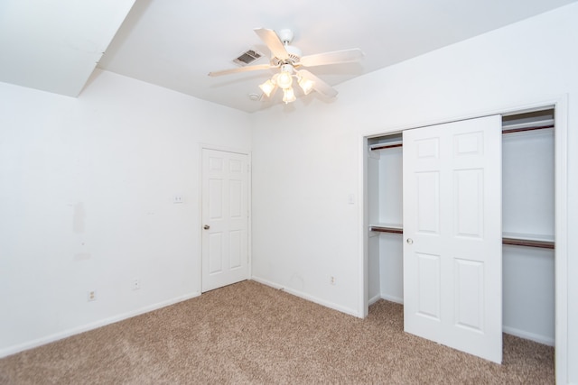 unfurnished bedroom with a closet, light colored carpet, and ceiling fan