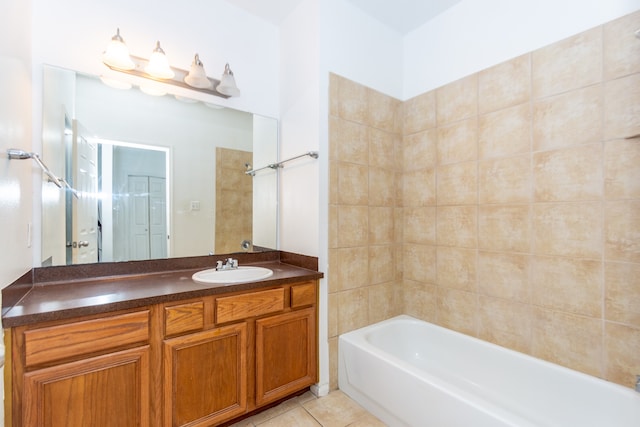 bathroom featuring tiled shower / bath, tile patterned floors, and vanity