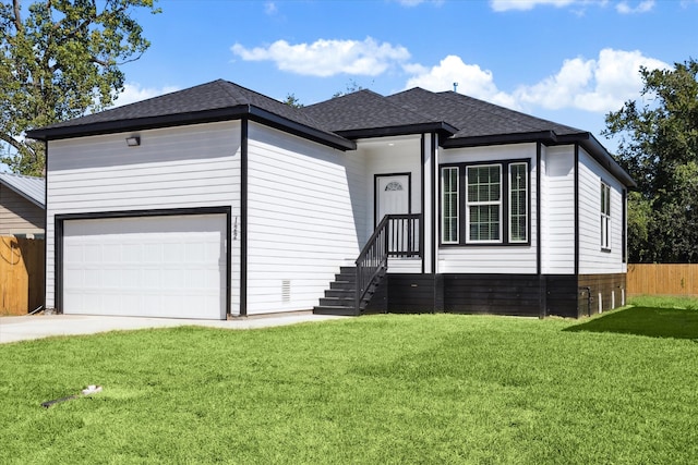 view of front of property featuring a front yard and a garage