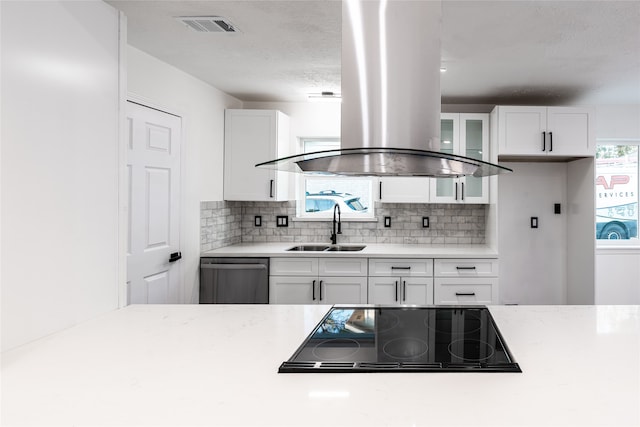 kitchen featuring stainless steel dishwasher, island exhaust hood, white cabinets, and sink