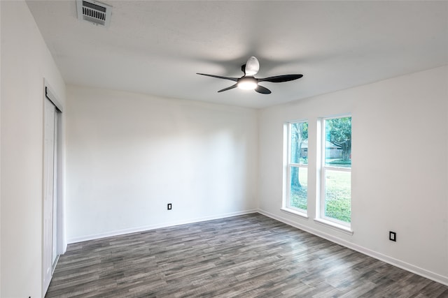 empty room with dark hardwood / wood-style flooring and ceiling fan