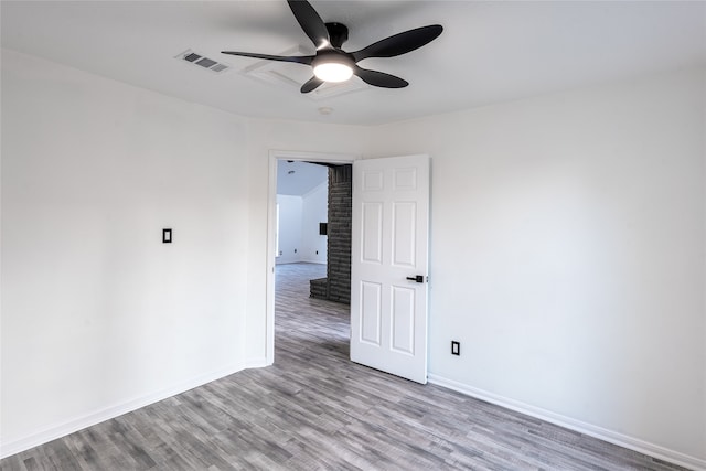 empty room with ceiling fan and light hardwood / wood-style flooring