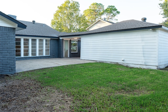 back of house featuring a patio and a lawn