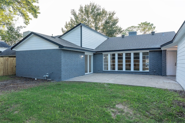 back of house with a lawn and a patio area