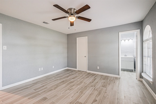 unfurnished bedroom featuring light wood-type flooring, ceiling fan, and ensuite bathroom